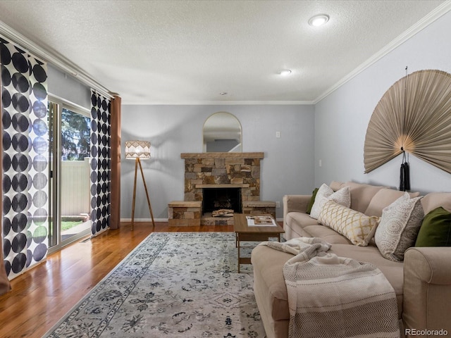 9696 E Kansas Cir Unit 2, Denver, CO 80247 - living area with a textured ceiling, wood finished floors, crown molding, and a stone fireplace
