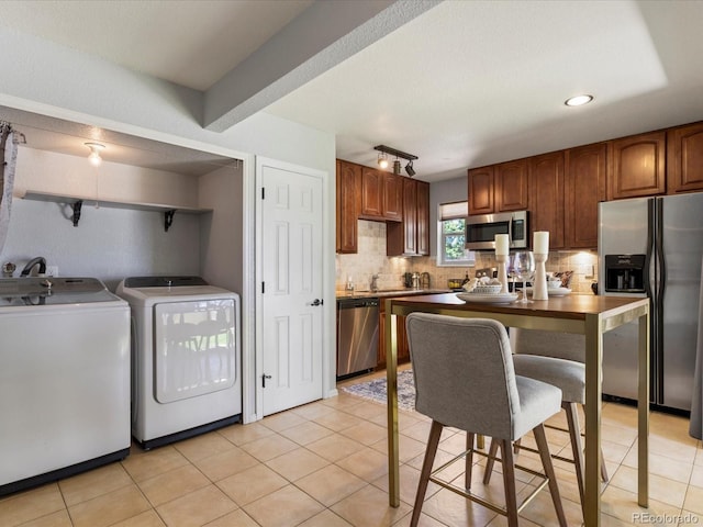 9696 E Kansas Cir Unit 2, Denver, CO 80247 - kitchen with appliances with stainless steel finishes, independent washer and dryer, backsplash, light tile patterned floors, and recessed lighting