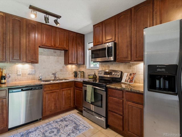 9696 E Kansas Cir Unit 2, Denver, CO 80247 - kitchen featuring appliances with stainless steel finishes, dark stone countertops, light tile patterned floors, and decorative backsplash