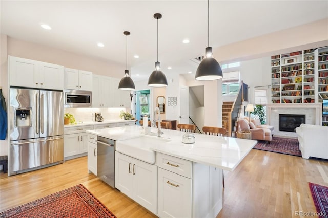 1455 Flowers Ct, Erie, CO 80516 - kitchen featuring a sink, white cabinets, a wealth of natural light, and stainless steel appliances