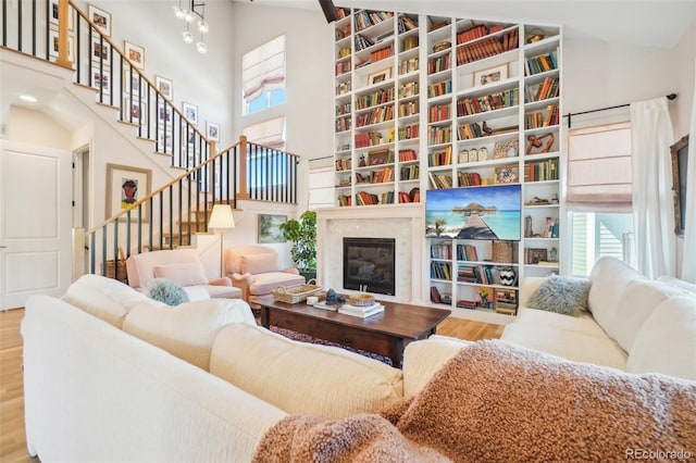1455 Flowers Ct, Erie, CO 80516 - living area with a high end fireplace, stairs, wood finished floors, and a towering ceiling
