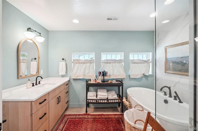 1455 Flowers Ct, Erie, CO 80516 - bathroom featuring recessed lighting, visible vents, a freestanding bath, and vanity