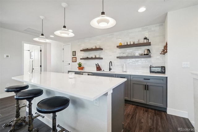 1455 Flowers Ct, Erie, CO 80516 - bar featuring backsplash, visible vents, hanging light fixtures, a sink, and dark wood-type flooring