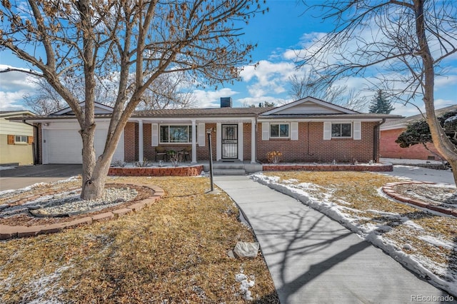 single story home featuring concrete driveway, brick siding, a chimney, and an attached garage