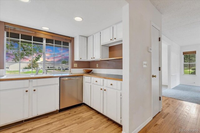 kitchen featuring white cabinetry, light hardwood / wood-style flooring, a textured ceiling, dishwasher, and sink