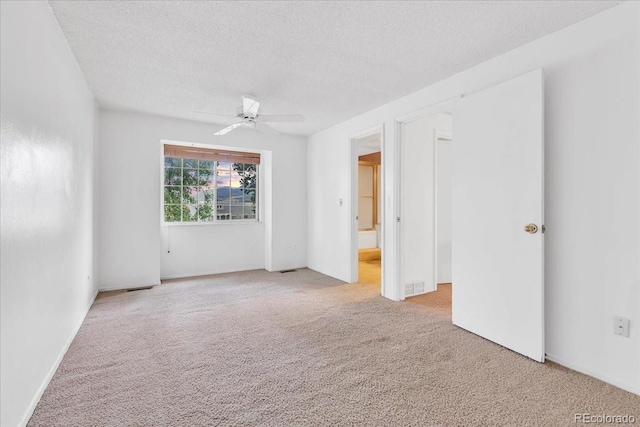 unfurnished bedroom featuring a textured ceiling, ceiling fan, and light colored carpet