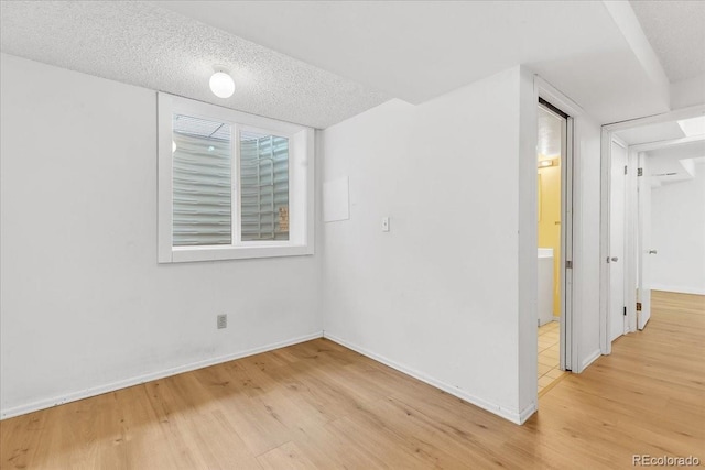 unfurnished room featuring a textured ceiling and light hardwood / wood-style floors