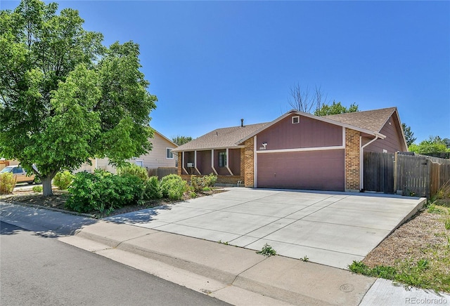 ranch-style home featuring brick siding, an attached garage, fence, concrete driveway, and a shingled roof