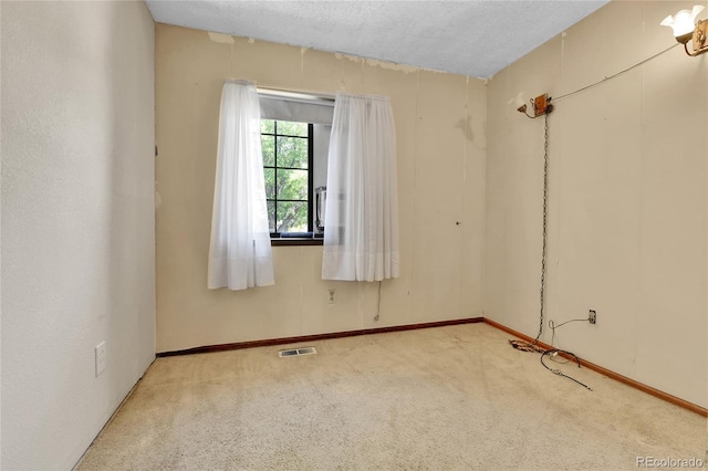 carpeted spare room featuring baseboards