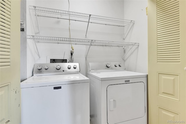 clothes washing area with washer and clothes dryer
