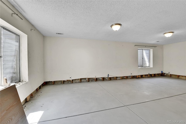 empty room with concrete floors and a textured ceiling