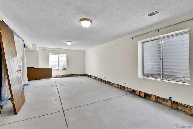 unfurnished room featuring finished concrete floors and a textured ceiling