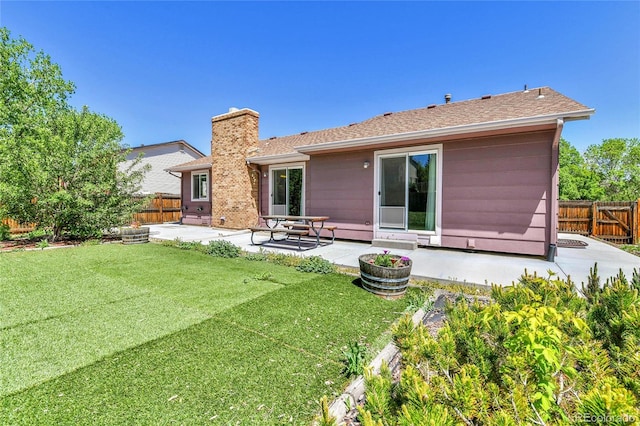 rear view of property featuring a patio area, a chimney, and a shingled roof