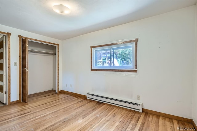 unfurnished bedroom featuring a closet, light hardwood / wood-style flooring, and a baseboard radiator