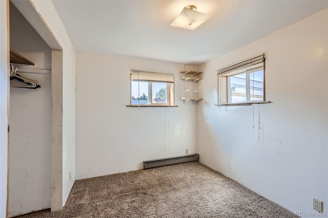 unfurnished bedroom featuring a closet, carpet, multiple windows, and a baseboard radiator