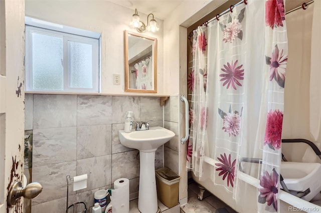 bathroom with sink, tile walls, and shower / tub combo