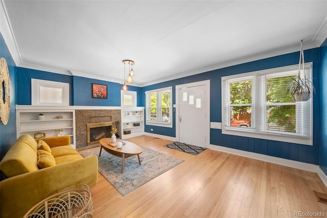 living room featuring crown molding, hardwood / wood-style flooring, and a fireplace