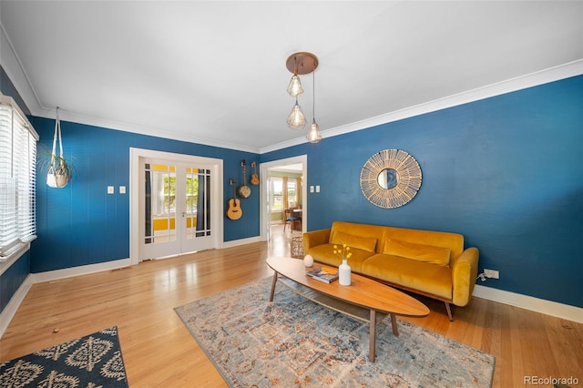 living room featuring light hardwood / wood-style flooring, ornamental molding, and french doors