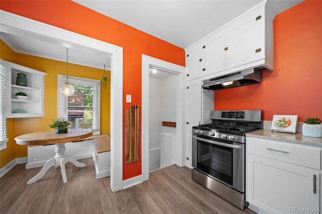 kitchen with breakfast area, hanging light fixtures, stainless steel gas range oven, and white cabinets