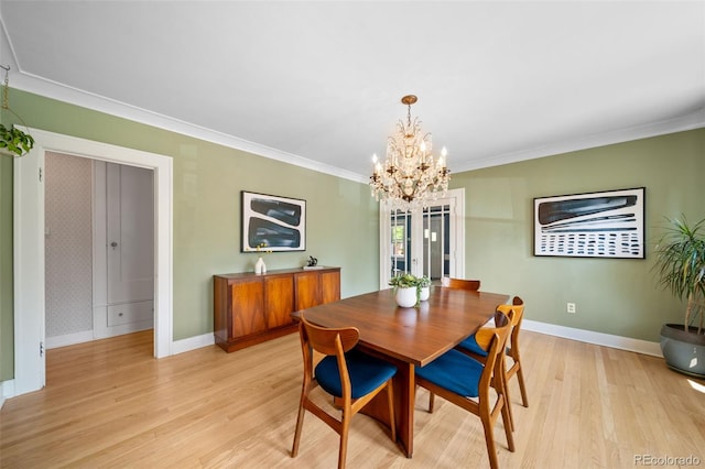 dining area with an inviting chandelier, ornamental molding, and light hardwood / wood-style floors