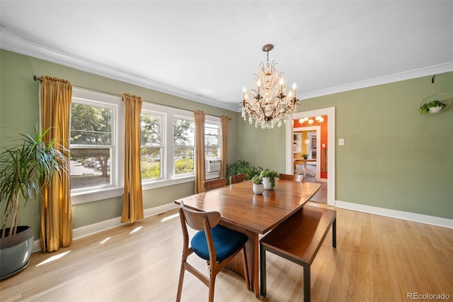 dining space featuring an inviting chandelier, ornamental molding, and light hardwood / wood-style floors