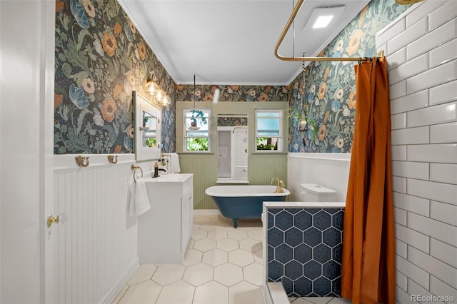 full bathroom featuring plus walk in shower, tile patterned flooring, ornamental molding, vanity, and toilet