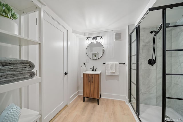 bathroom with vanity, an enclosed shower, and hardwood / wood-style flooring