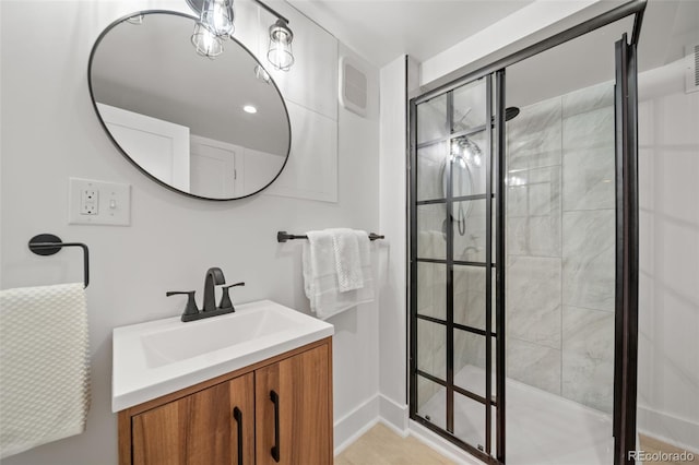 bathroom with tiled shower and vanity