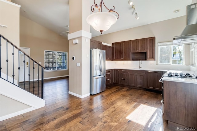 kitchen with appliances with stainless steel finishes, dark hardwood / wood-style floors, extractor fan, and plenty of natural light