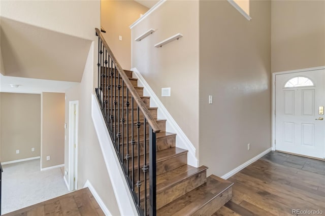 stairs with a high ceiling and hardwood / wood-style floors