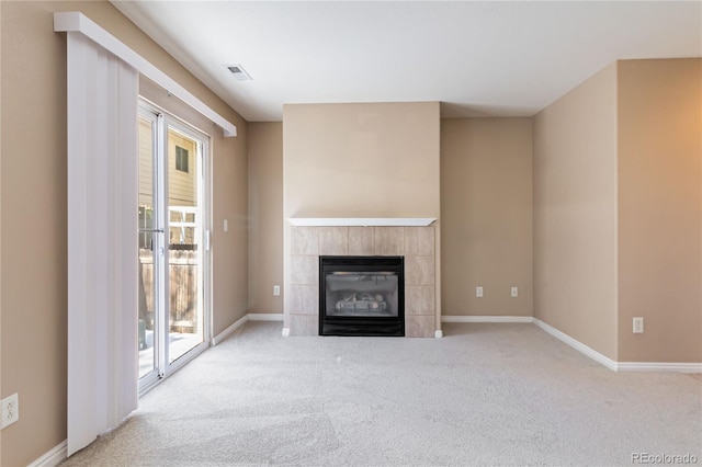 unfurnished living room with light carpet, a tile fireplace, and a wealth of natural light