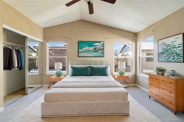 bedroom with lofted ceiling, a closet, ceiling fan, and light colored carpet