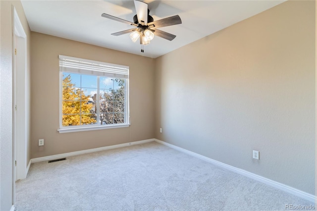 spare room with ceiling fan and light colored carpet