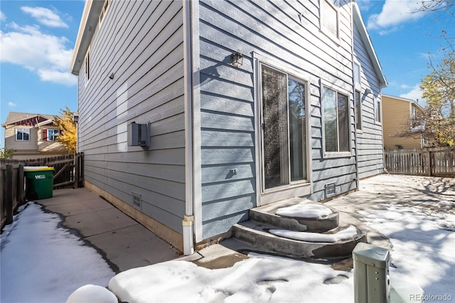 snow covered property with an AC wall unit