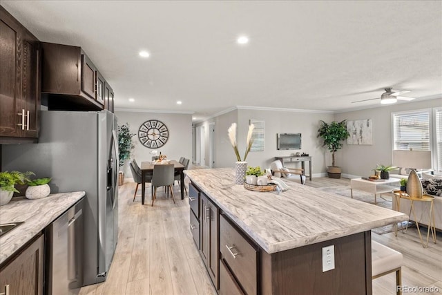 kitchen with stainless steel dishwasher, ceiling fan, a kitchen island, and crown molding