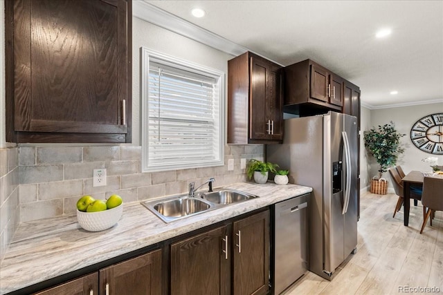 kitchen featuring crown molding, sink, appliances with stainless steel finishes, light hardwood / wood-style floors, and dark brown cabinetry