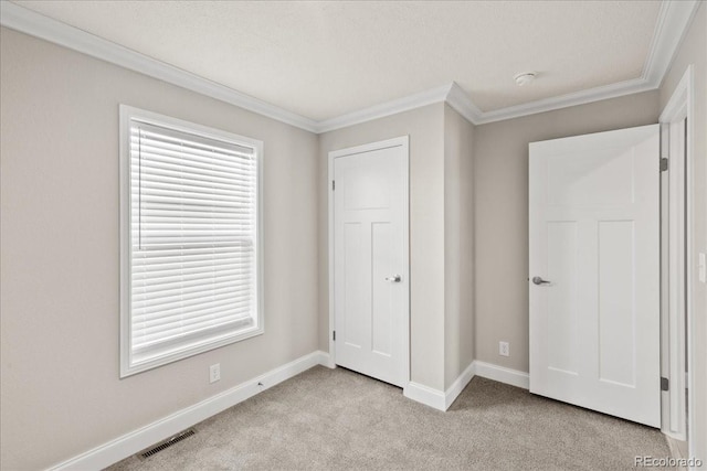 unfurnished bedroom with multiple windows, light carpet, and crown molding