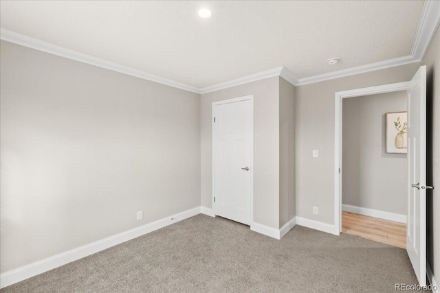 unfurnished bedroom featuring light carpet and crown molding