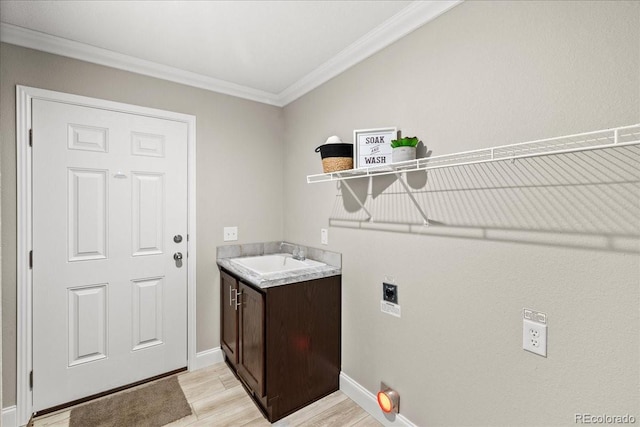 clothes washing area with sink, cabinets, hookup for an electric dryer, light hardwood / wood-style floors, and ornamental molding