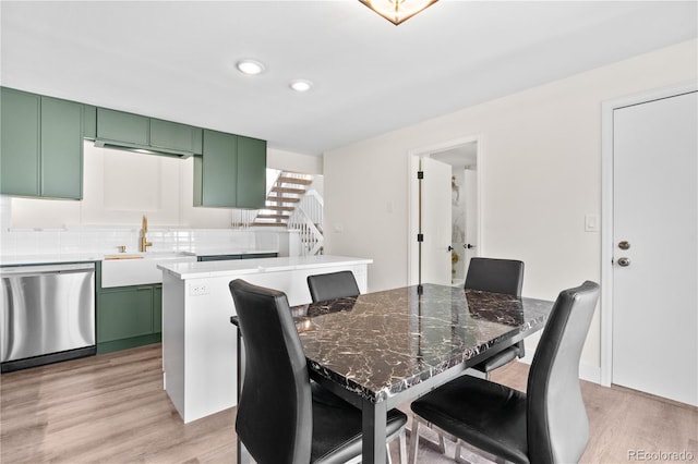 dining space with light wood-type flooring and sink