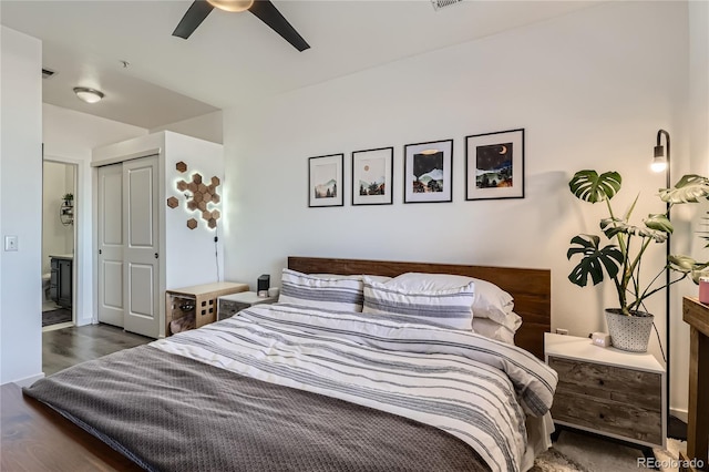 bedroom featuring dark hardwood / wood-style floors, ceiling fan, and a closet