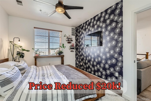 4100 Albion St Unit 221, Denver, CO 80216 - bedroom with an accent wall, wallpapered walls, baseboards, ceiling fan, and wood finished floors