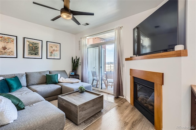 4100 Albion St Unit 221, Denver, CO 80216 - living area with wood finished floors, a glass covered fireplace, and a ceiling fan