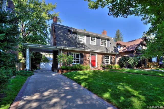 view of front of house with a front yard, driveway, brick siding, an attached carport, and a chimney