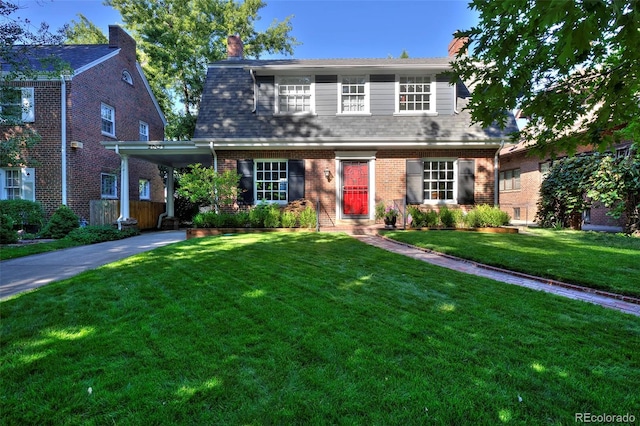 view of front of property featuring a carport, a front lawn, driveway, and brick siding