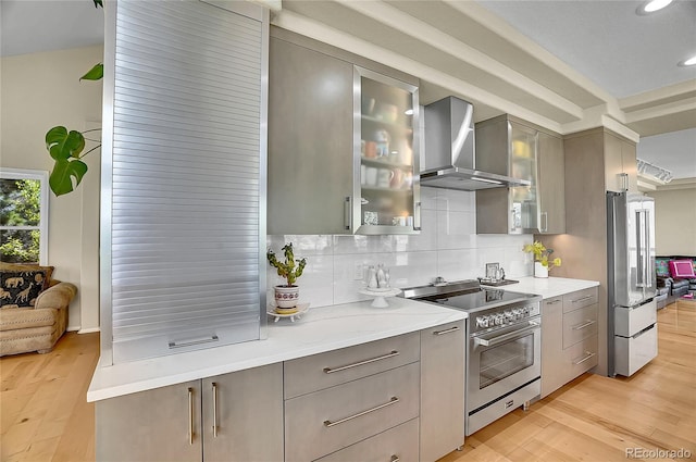 165 Washington St, Golden, CO 80403 - kitchen featuring premium appliances, gray cabinetry, wall chimney exhaust hood, light wood-style flooring, and decorative backsplash