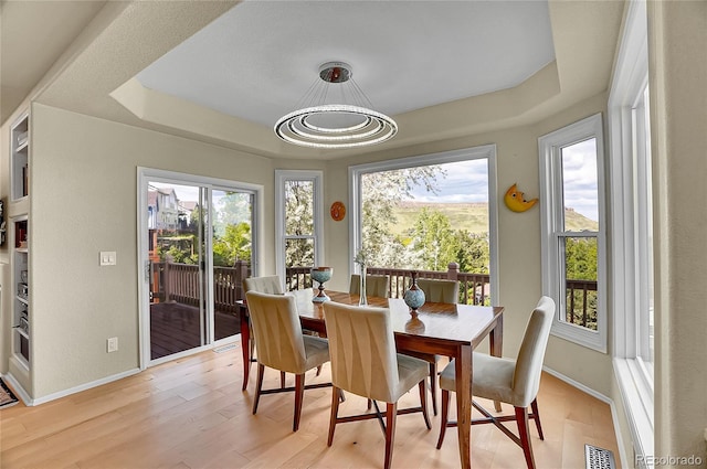 165 Washington St, Golden, CO 80403 - dining room featuring a tray ceiling, baseboards, and light wood-type flooring
