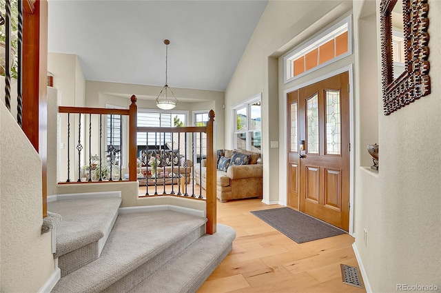 165 Washington St, Golden, CO 80403 - foyer featuring light wood-style flooring, baseboards, a textured wall, high vaulted ceiling, and stairs