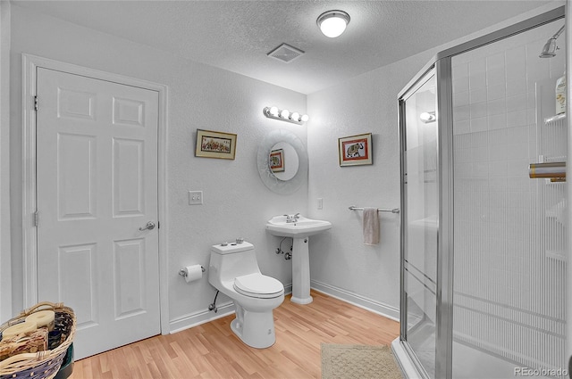165 Washington St, Golden, CO 80403 - bathroom with wood finished floors, a stall shower, a textured wall, toilet, and a textured ceiling
