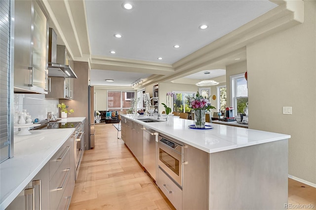 165 Washington St, Golden, CO 80403 - kitchen with modern cabinets, wall chimney exhaust hood, a sink, light wood-type flooring, and light stone counters